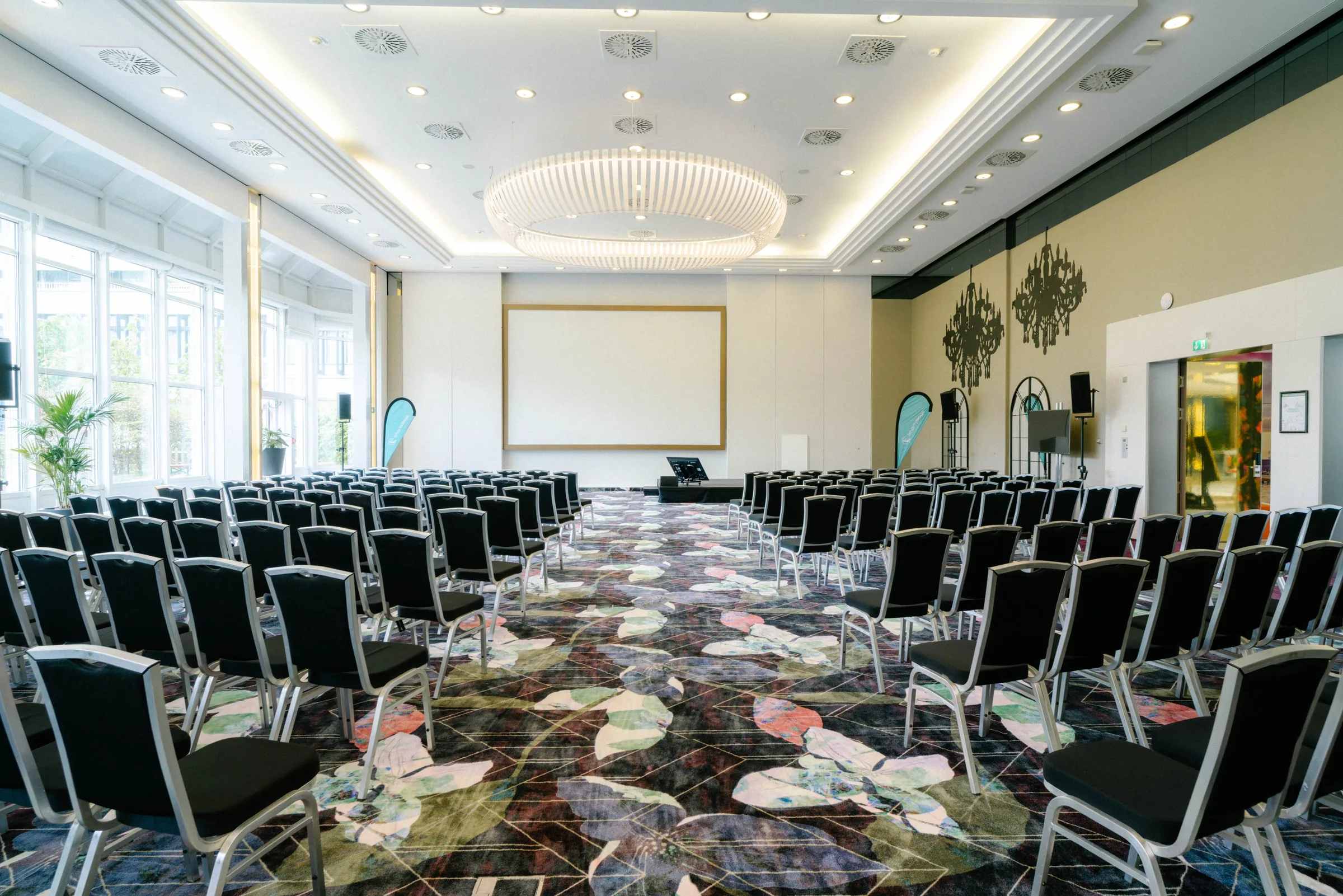 Ballsaal im smartvillage München Bogenhausen mit Kronleuchter und Reihenbestuhlung