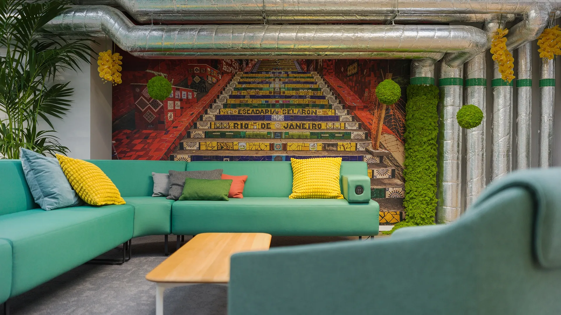 Gemütliche Lounge-Ecke mit farbigen Kissen und Wandgestaltung der Escadaria Selarón aus Rio de Janeiro.
