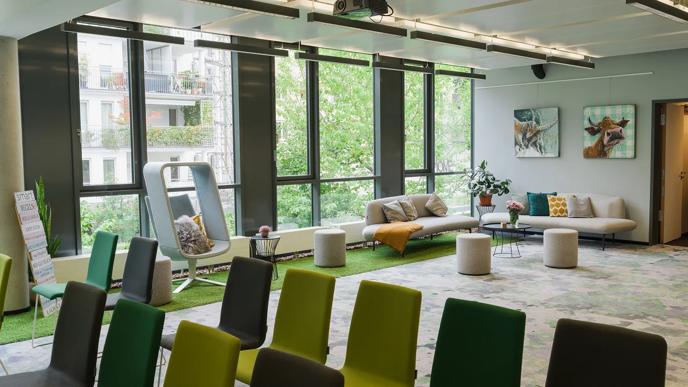 Stuhlreihen treffen Lounge — mit Design-Ohrensessel am Fenster